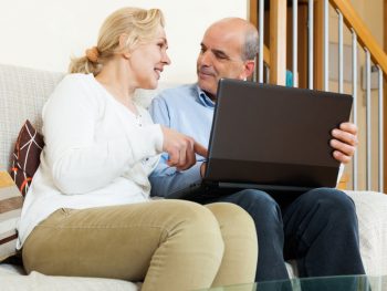 Smiling mature couple with laptop